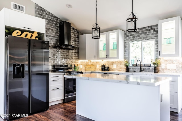 kitchen with a kitchen island, stainless steel appliances, white cabinetry, and wall chimney exhaust hood