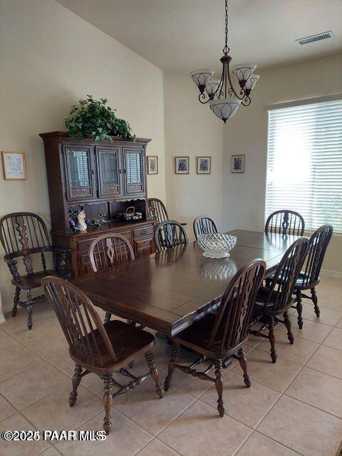 dining area featuring visible vents, a notable chandelier, baseboards, and light tile patterned floors