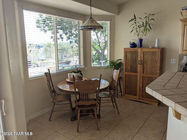 dining space with light tile patterned floors and baseboards