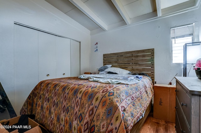 bedroom with beam ceiling and hardwood / wood-style flooring