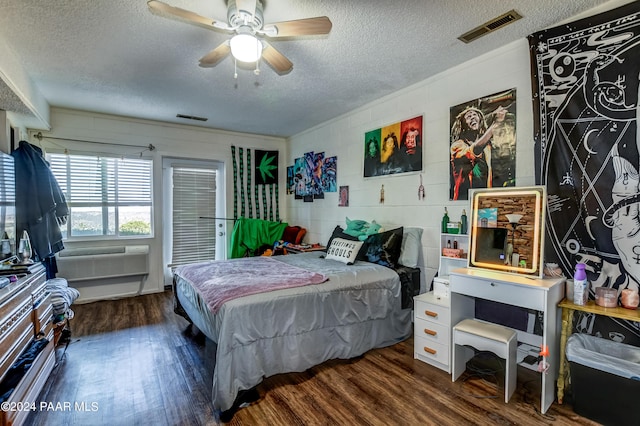 bedroom featuring a wall mounted AC, ceiling fan, dark hardwood / wood-style flooring, and a textured ceiling