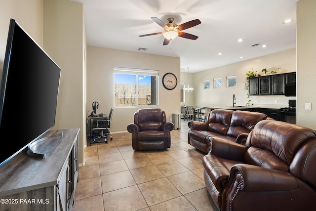 living room with sink, light tile patterned floors, and ceiling fan