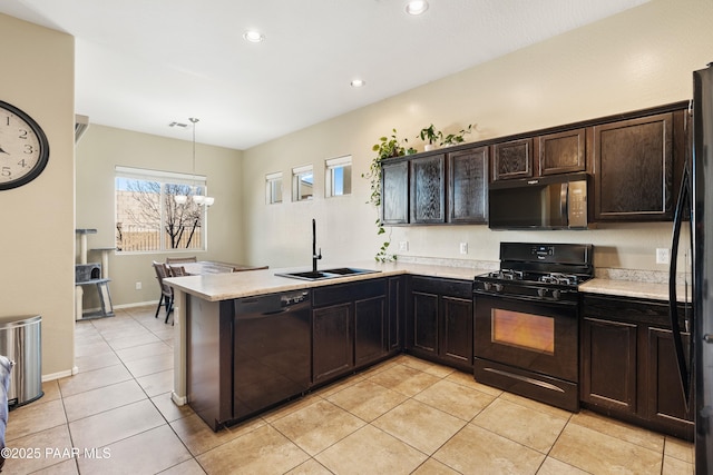 kitchen featuring sink, hanging light fixtures, dark brown cabinets, black appliances, and kitchen peninsula