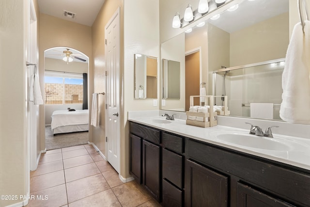 bathroom featuring tile patterned flooring, vanity, a shower with shower door, and ceiling fan