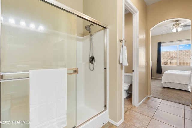 bathroom featuring ceiling fan, tile patterned floors, toilet, and walk in shower