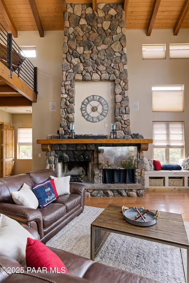 living room featuring wooden ceiling, lofted ceiling with beams, a fireplace, and hardwood / wood-style flooring