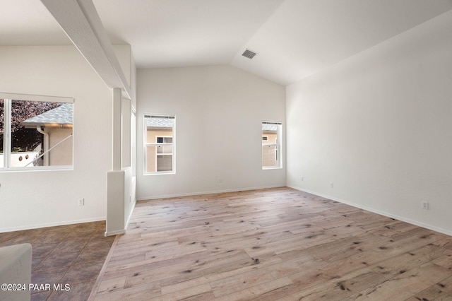 spare room featuring hardwood / wood-style floors and lofted ceiling