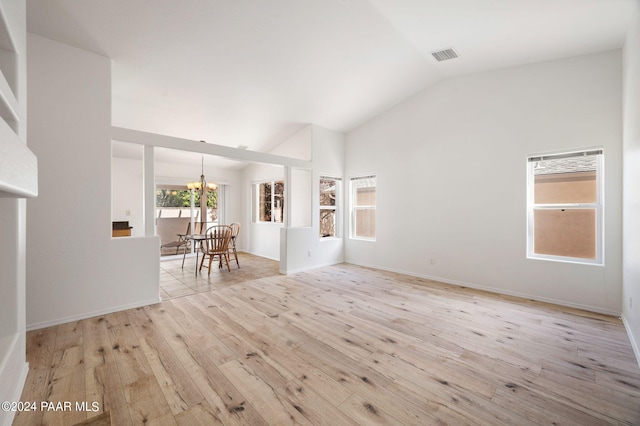 unfurnished living room featuring vaulted ceiling, light hardwood / wood-style flooring, and a notable chandelier