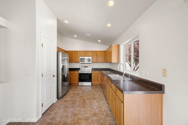 kitchen with sink, light tile patterned floors, stainless steel appliances, and vaulted ceiling