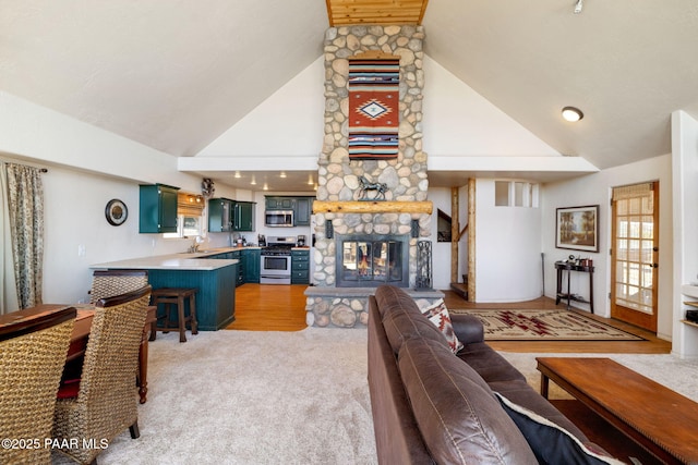 living room with light carpet, a fireplace, and high vaulted ceiling