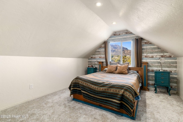 carpeted bedroom featuring vaulted ceiling and a textured ceiling