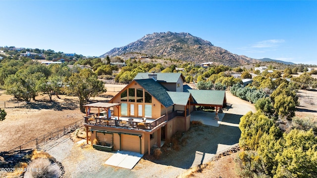 6850 N Harris Dr, Prescott, AZ 86305 - back of house featuring fence, an attached garage, a deck with mountain view, roof with shingles, and driveway