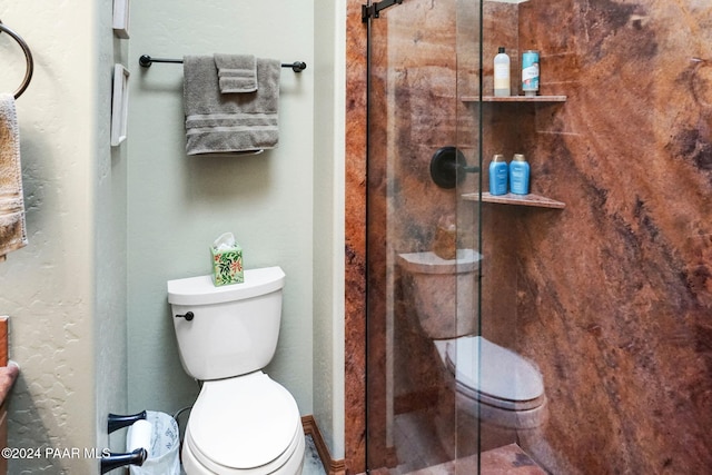 bathroom featuring an enclosed shower and toilet