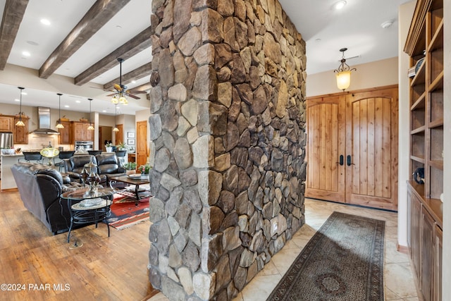 interior space featuring beam ceiling, light hardwood / wood-style floors, and ceiling fan