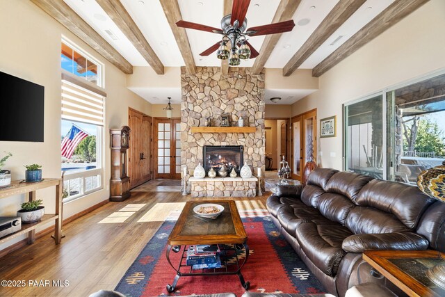 living room featuring beamed ceiling, ceiling fan, and light hardwood / wood-style floors