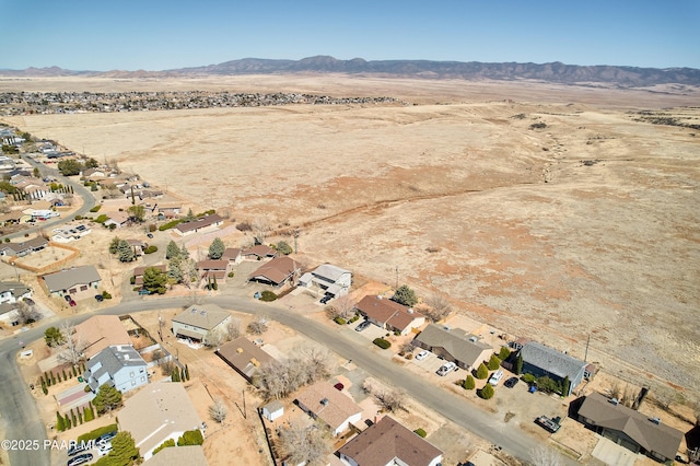 drone / aerial view featuring a residential view, a mountain view, and view of desert