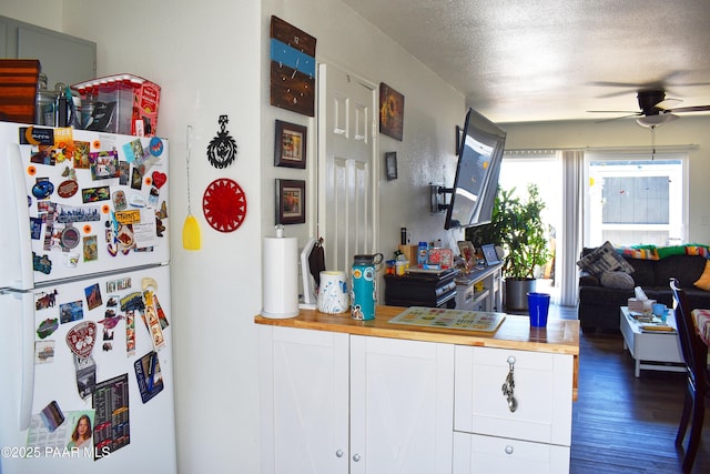 kitchen with wooden counters, a textured ceiling, ceiling fan, and freestanding refrigerator