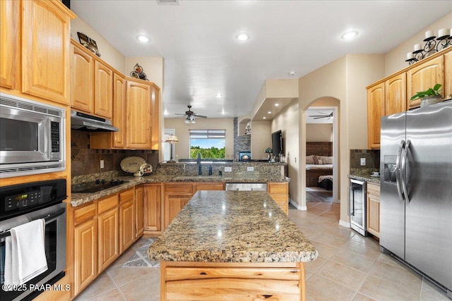 1395 N Rustlers Roost, Dewey-Humboldt, AZ 86327 - kitchen with appliances with stainless steel finishes, ceiling fan, a kitchen island, and light tile patterned flooring