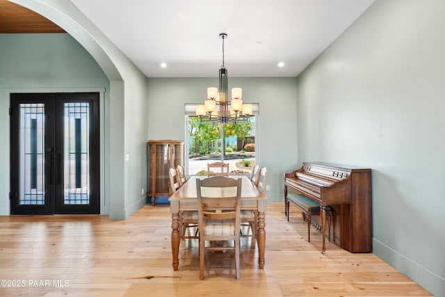 dining room with arched walkways, baseboards, a chandelier, and french doors