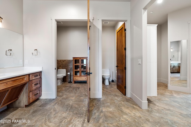 bathroom featuring vanity, toilet, and marble finish floor