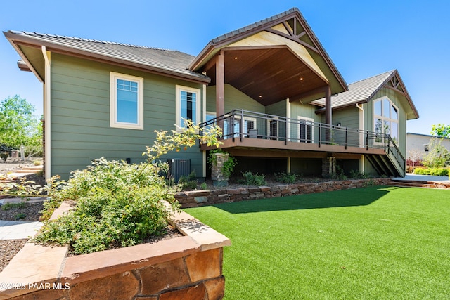 rear view of house with a lawn, central AC unit, and a deck