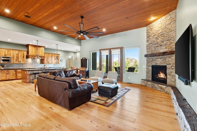 living room featuring a fireplace, light wood-type flooring, recessed lighting, wooden ceiling, and a ceiling fan