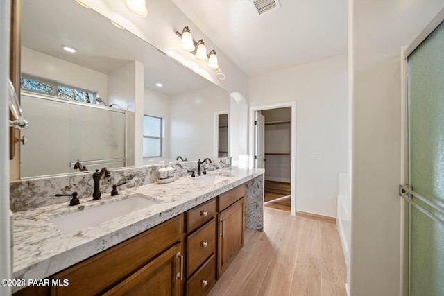 bathroom with hardwood / wood-style floors, vanity, and plus walk in shower