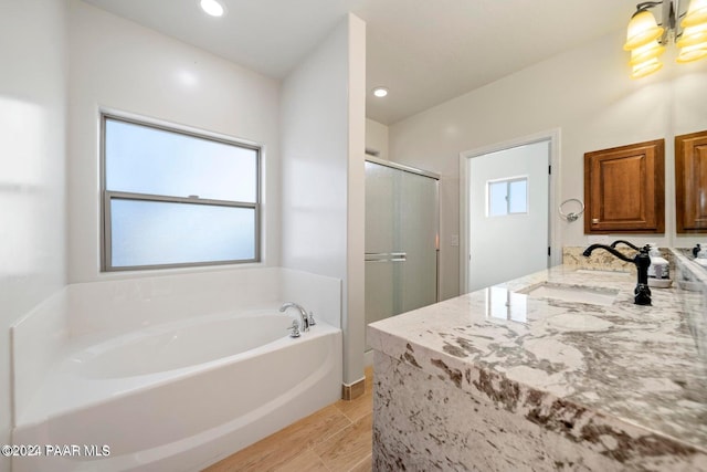 bathroom with hardwood / wood-style flooring, sink, and plus walk in shower