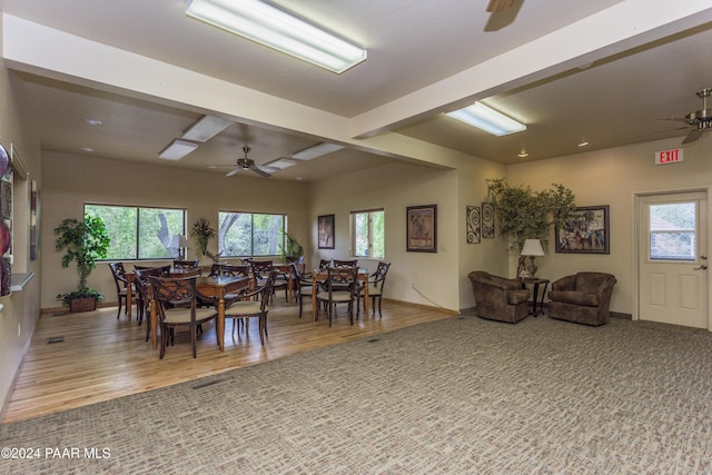 dining space with beam ceiling, ceiling fan, hardwood / wood-style floors, and a healthy amount of sunlight