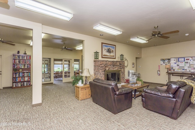 carpeted living room with a stone fireplace