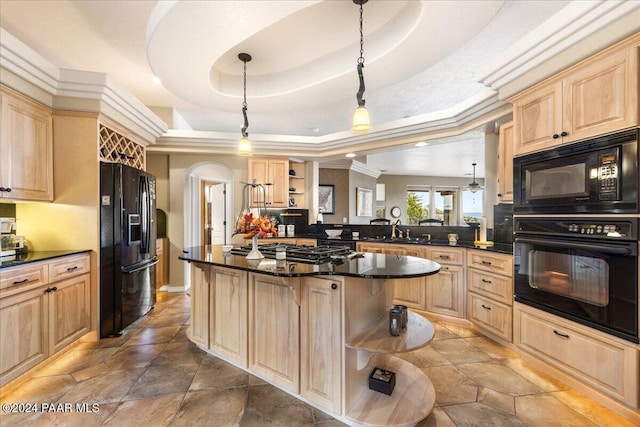 kitchen featuring kitchen peninsula, a raised ceiling, sink, black appliances, and pendant lighting