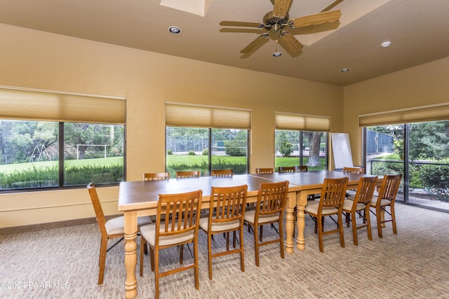 carpeted dining area with ceiling fan