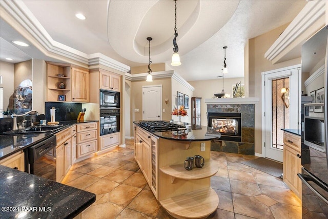 kitchen with a center island, black appliances, a multi sided fireplace, sink, and a tray ceiling