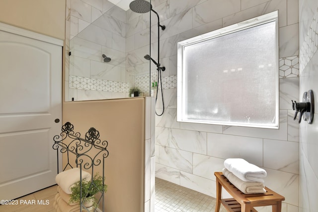 bathroom featuring a tile shower, tile patterned floors, and tile walls