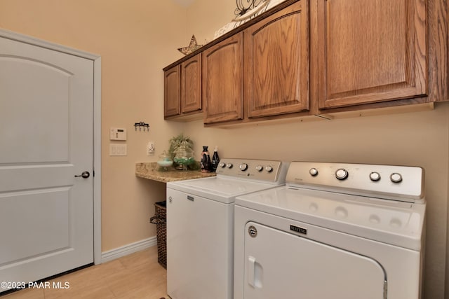 laundry area with washer and dryer and cabinets