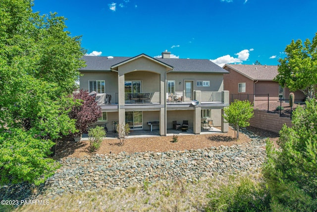 back of house featuring a balcony and a patio area