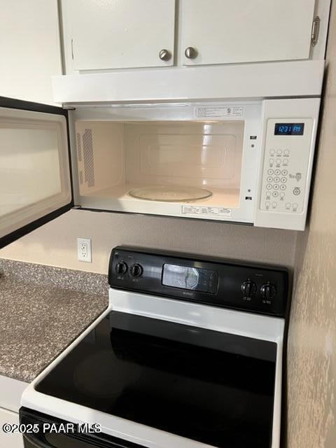 room details with range with electric stovetop and white microwave