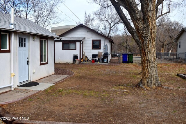 back of house with stucco siding and fence