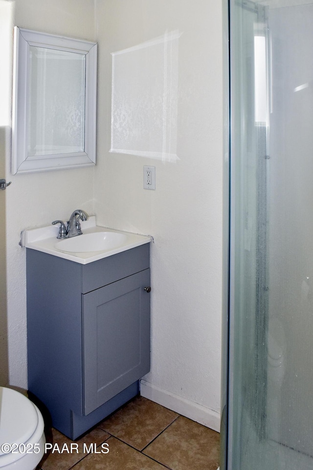 bathroom with tile patterned floors, baseboards, toilet, and vanity