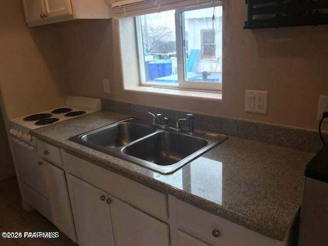 kitchen featuring white cabinetry and a sink