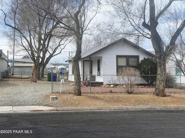 bungalow-style house with a fenced front yard and driveway