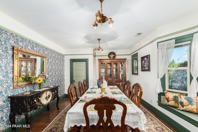 dining space featuring dark hardwood / wood-style floors and an inviting chandelier