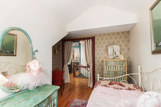 bedroom featuring hardwood / wood-style floors and vaulted ceiling