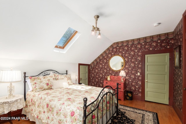 bedroom with wood-type flooring and lofted ceiling with skylight