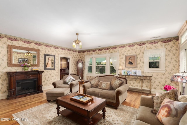 living room with light wood-type flooring and a notable chandelier