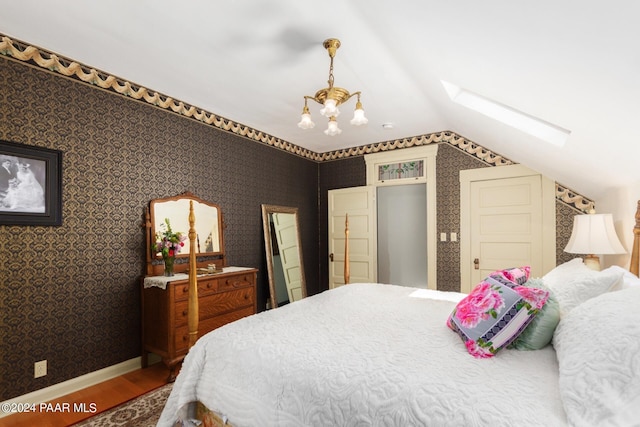 bedroom with wood-type flooring and lofted ceiling with skylight