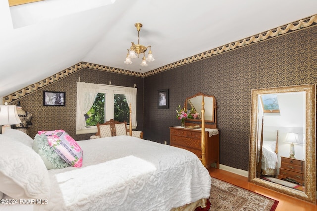 bedroom featuring a chandelier, wood-type flooring, and lofted ceiling