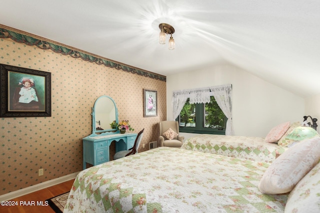 bedroom with hardwood / wood-style flooring and lofted ceiling