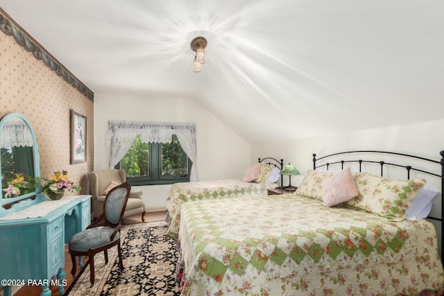 bedroom featuring vaulted ceiling and light wood-type flooring