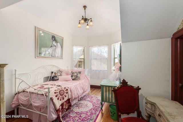 bedroom featuring a chandelier, wood-type flooring, and lofted ceiling